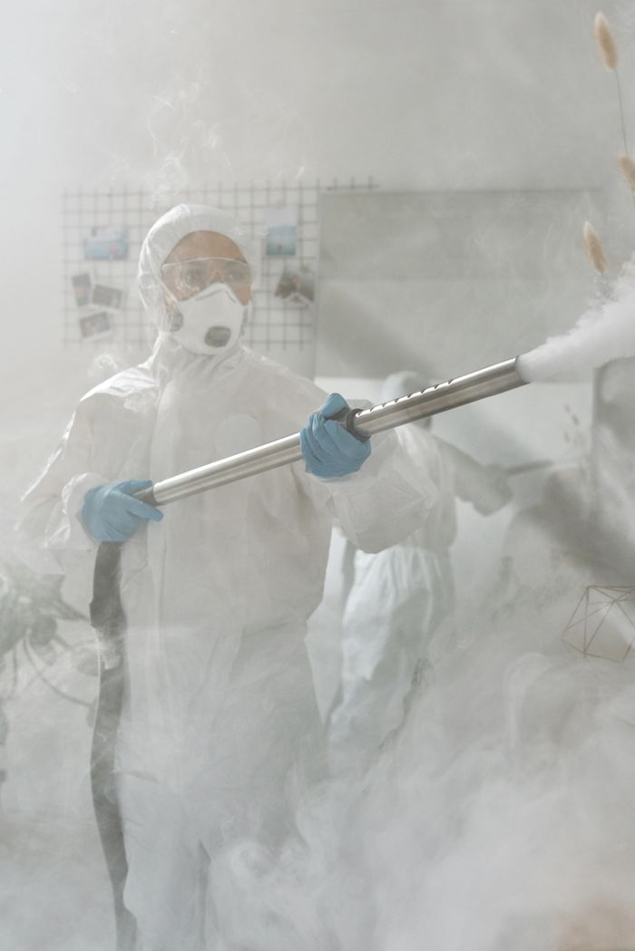 our-story A person in full protective gear fumigating a room to ensure sterilization against viruses.